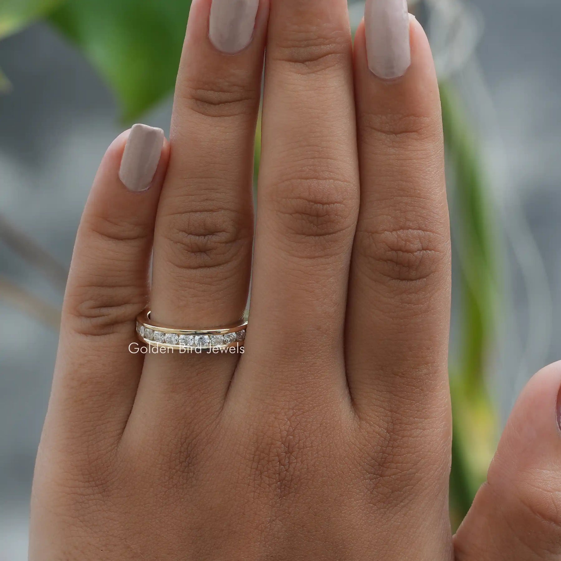 [In finger front view of round cut moissanite eternity band set in channel setting]-[Golden Bird Jewels]
