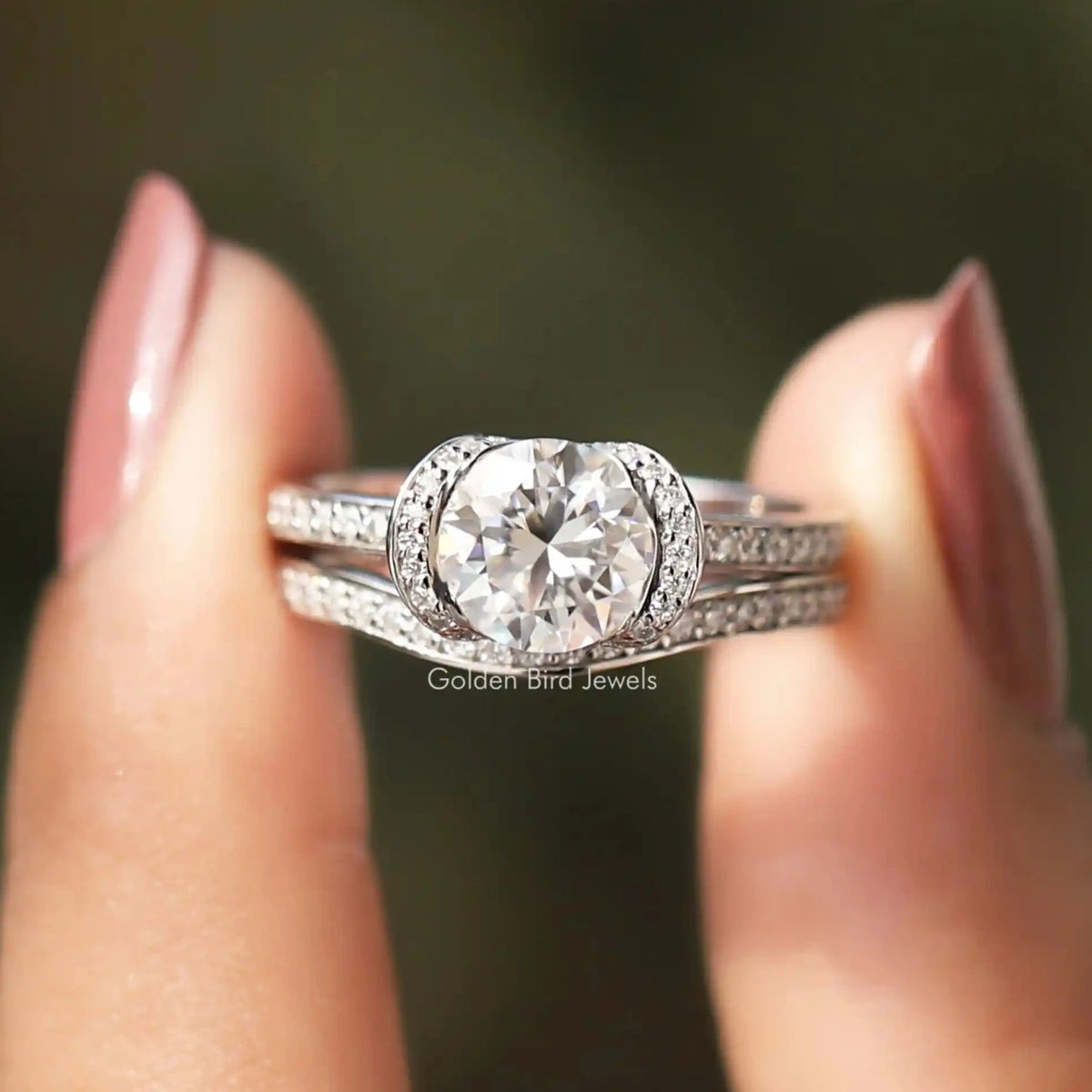 Two fingers holding the Round Cut Moissanite Halo Bridal Ring Set