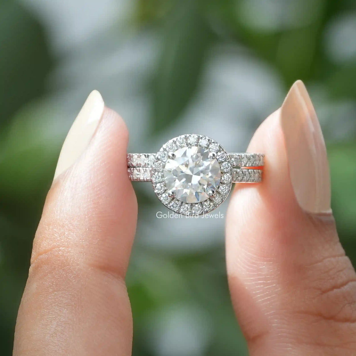 Two fingers holding the Round Cut Moissanite Halo Wedding Ring 