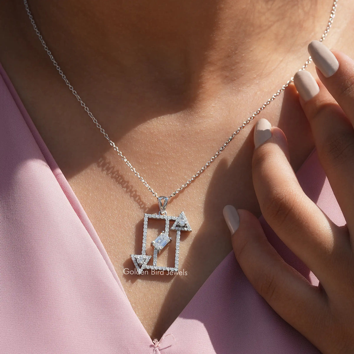 In neck front view of round and emerald cut white gold pendant
