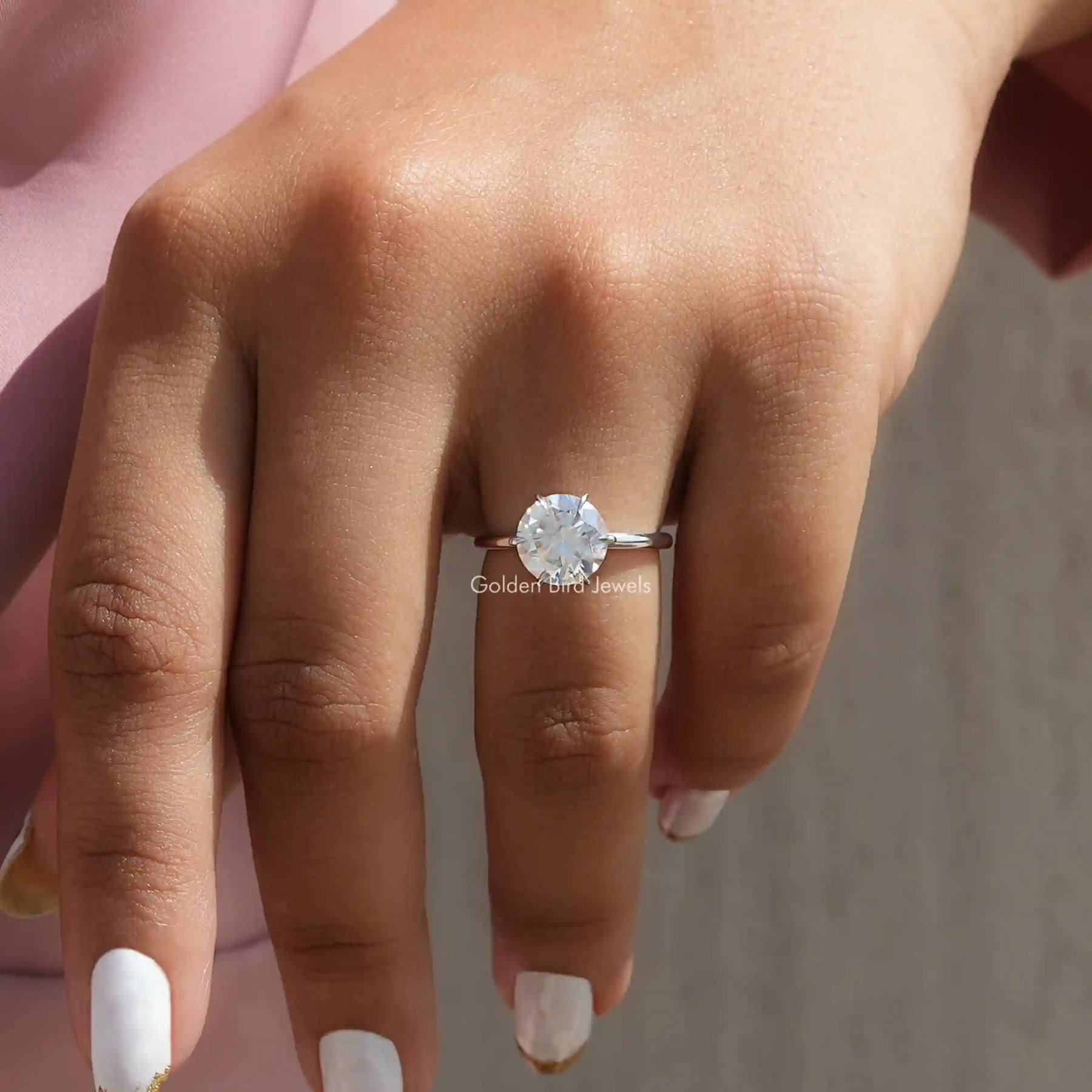 [In finger front view of solitaire round cut moissanite bridal ring]