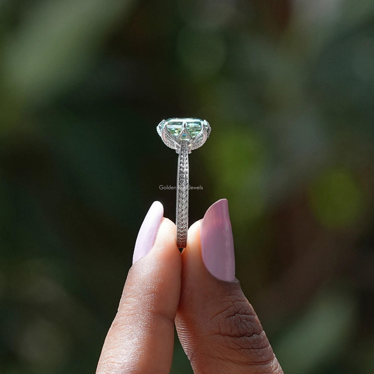 Side View of Green Cushion Cut Moissanite Ring In two fingers