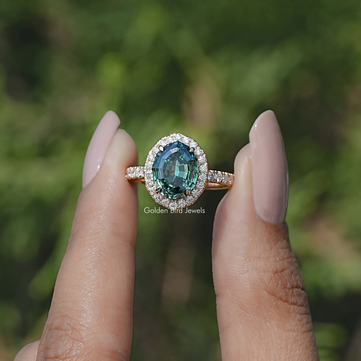 Front view of Step Cut Oval Moissanite Halo Accent Ring in two fingers 
