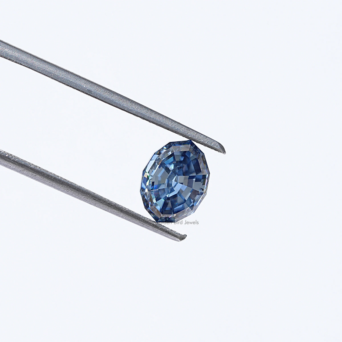 Twijer holding in the Step Cut Oval Moissanite Loose Stone In blue 