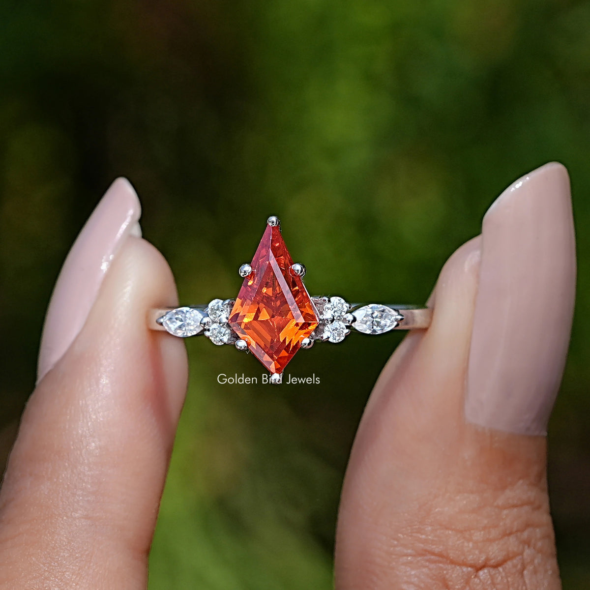 Front View of Orange Kite Cut Gemstone Accent Ring In two Fingers