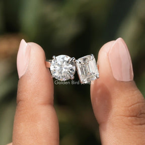 Front View of Emerald And Round Cut Moissanite Ring In two Fingers
