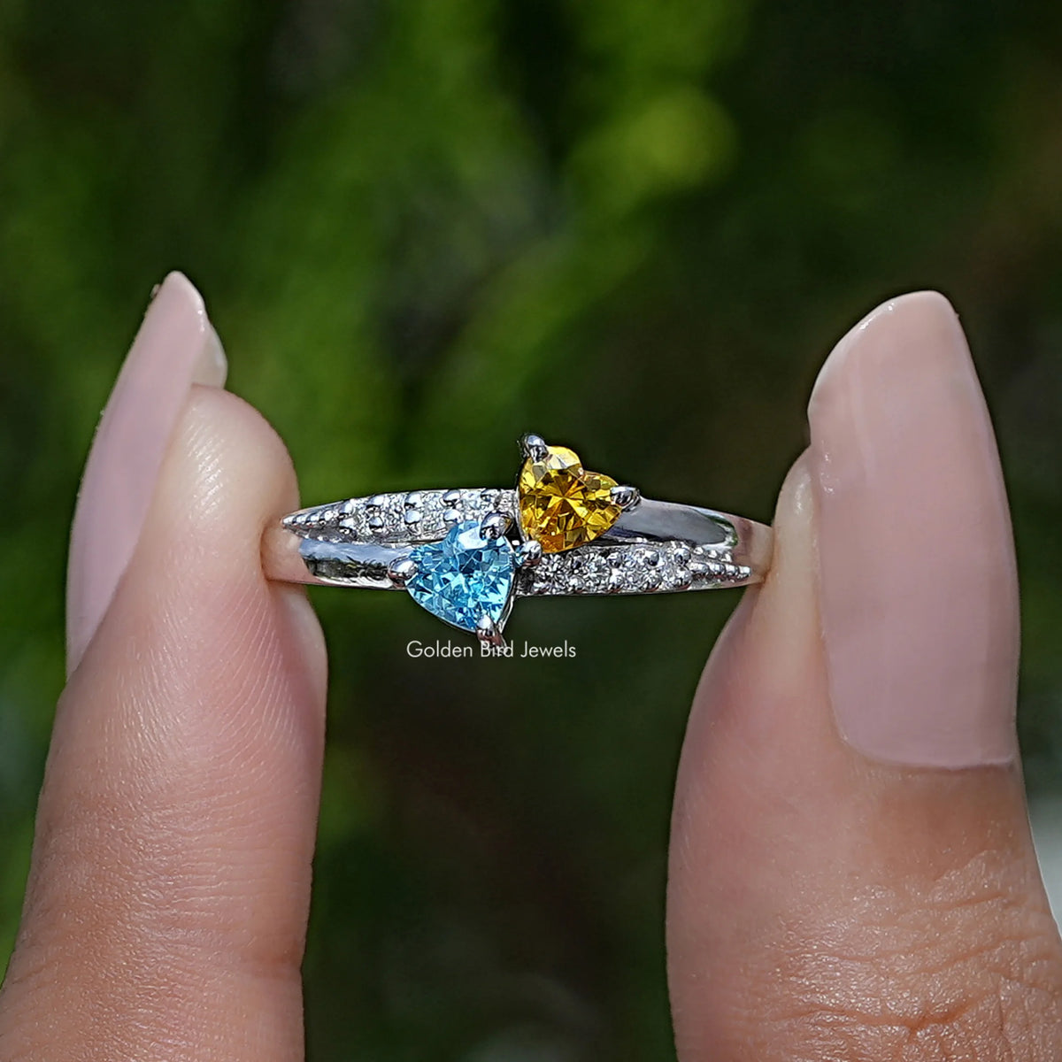 Two fingers holding the Toi Et Moi Heart Cut Accent Stone Ring