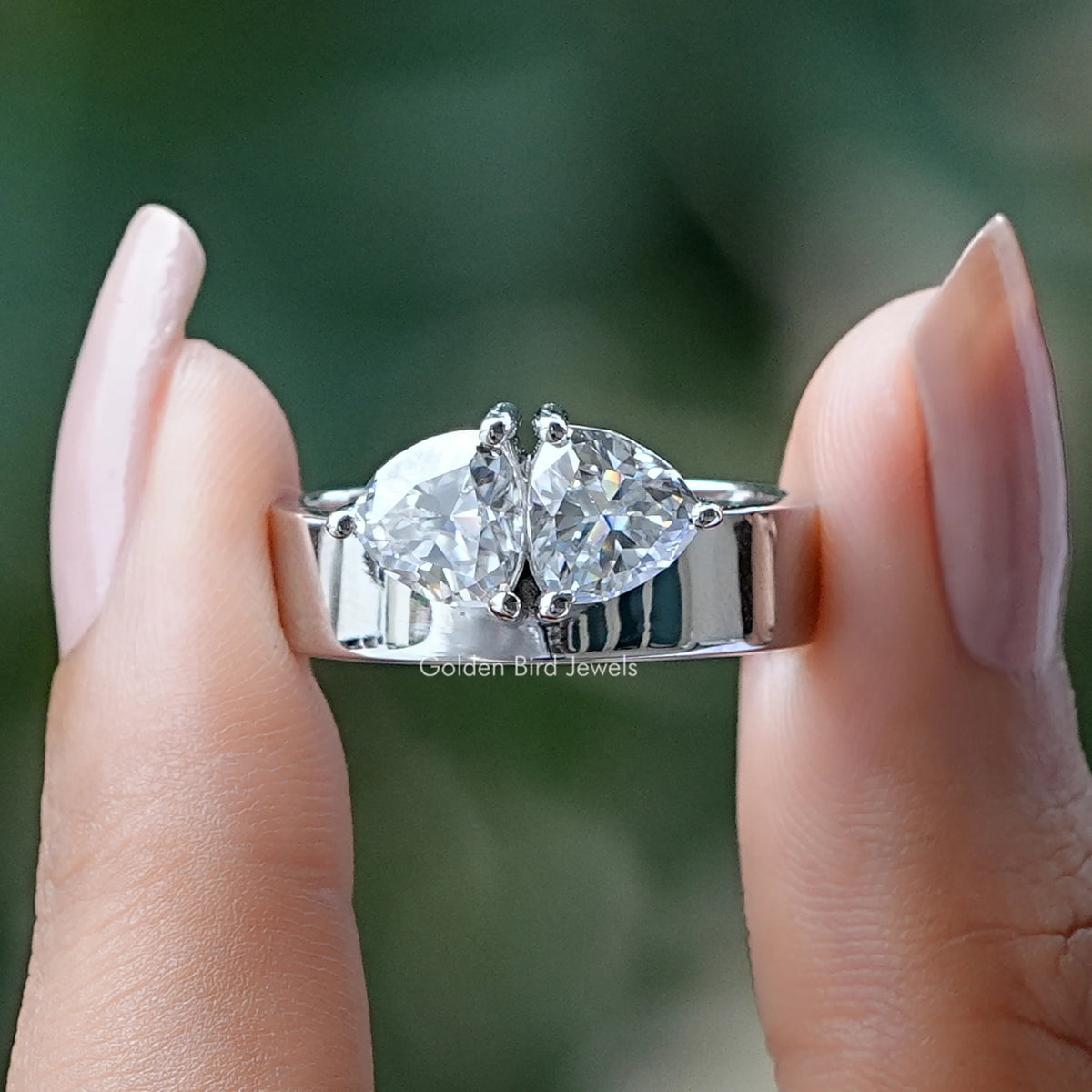 Front View of Trillion Cut Two Stone Moissanite Engagement Ring In two Fingers