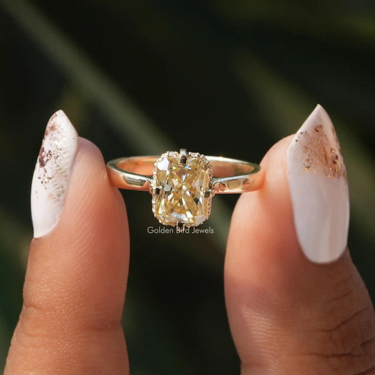 Yellow Radiant Cut Moissanite Hidden Halo Ring holding on  two fingers 