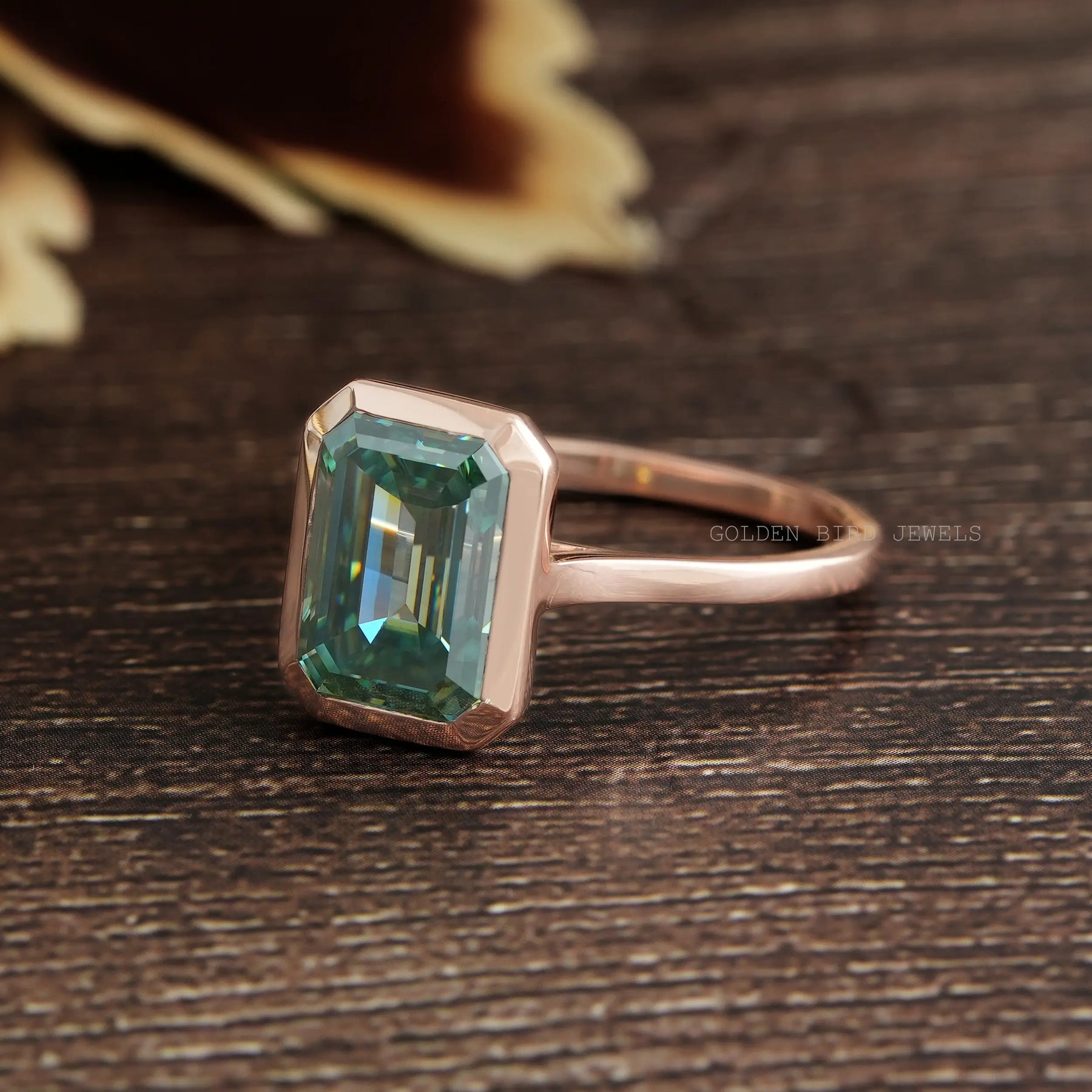 Left Side View Of Blue Green Emerald Cut Bezel Moissanite Engagement Ring