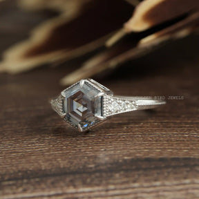Side View Of Grey Hexagon Cut Moissanite With Colorless Round Cut Moissanite As A Side Stone Engagement Ring