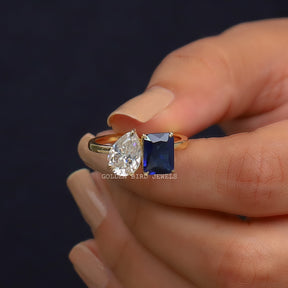 Front View of Emerald & Pear Cut Toi Et Moi Engagement Ring In two Fingers