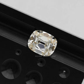 A photograph of an Old Mine Cushion Cut Moissanite, a sparkling, diamond-like gemstone