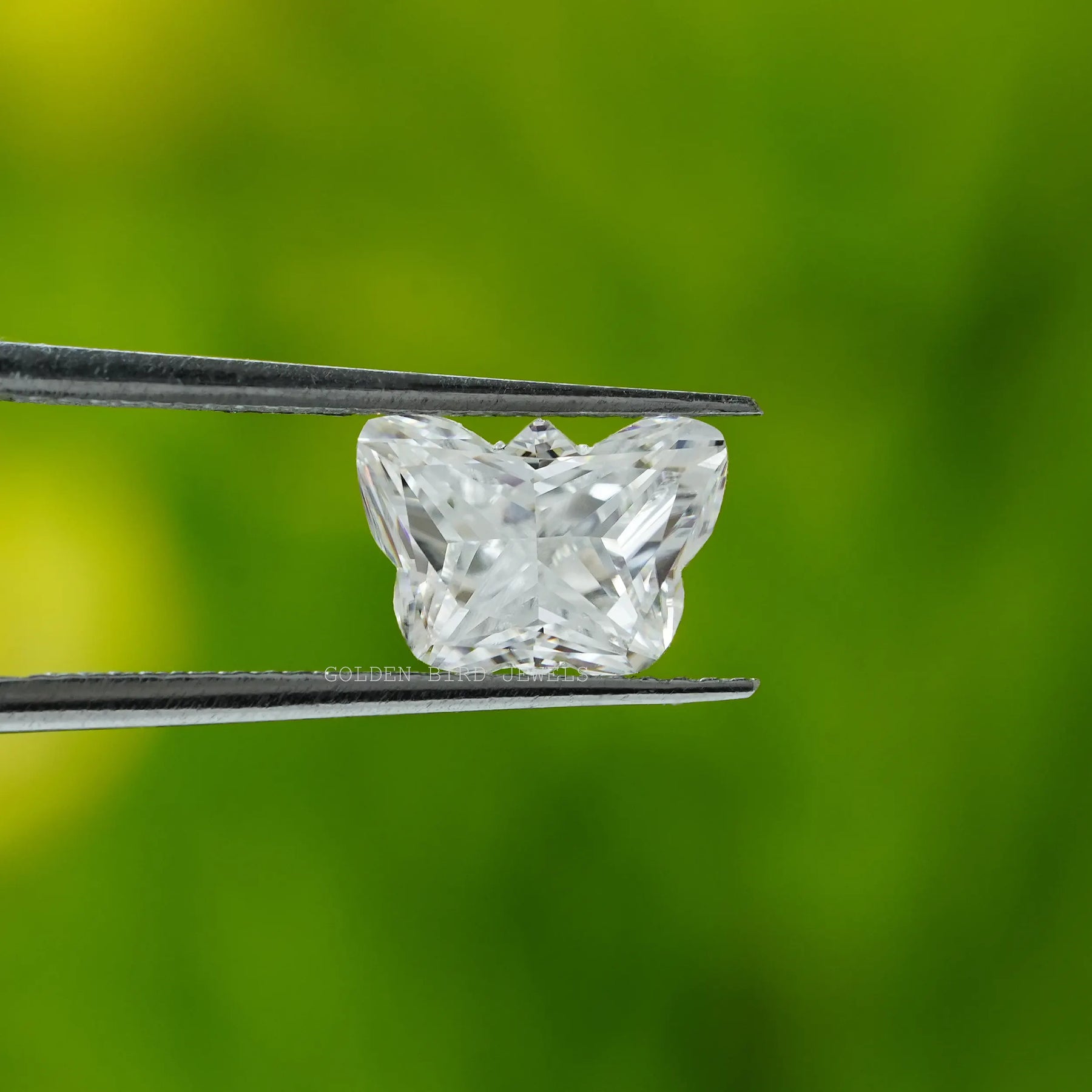 in tweezer front view of 2 carat colorless moissanite diamond